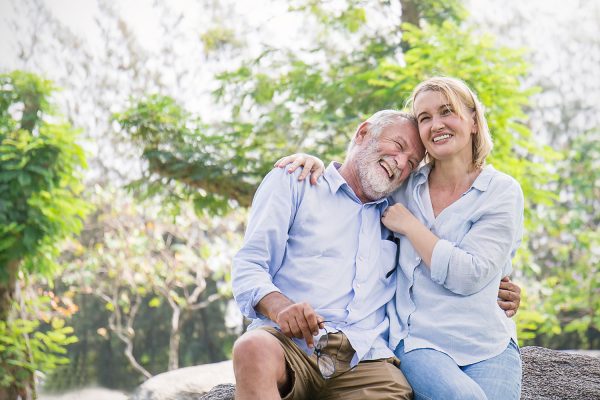 older couple laughing and hugging outdoors