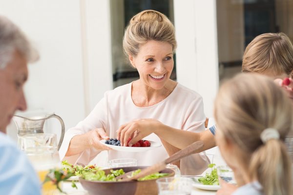 smiling grandmother sitting at dining table