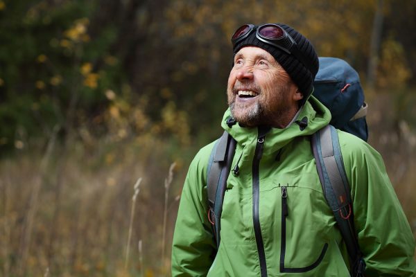 smiling man wearing backpack while hiking