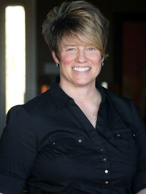 smiling woman with short hair wearing black shirt