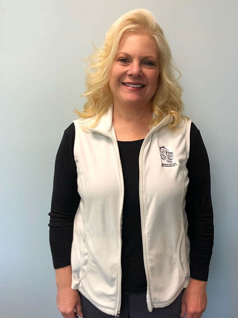 smiling blonde woman wearing white vest